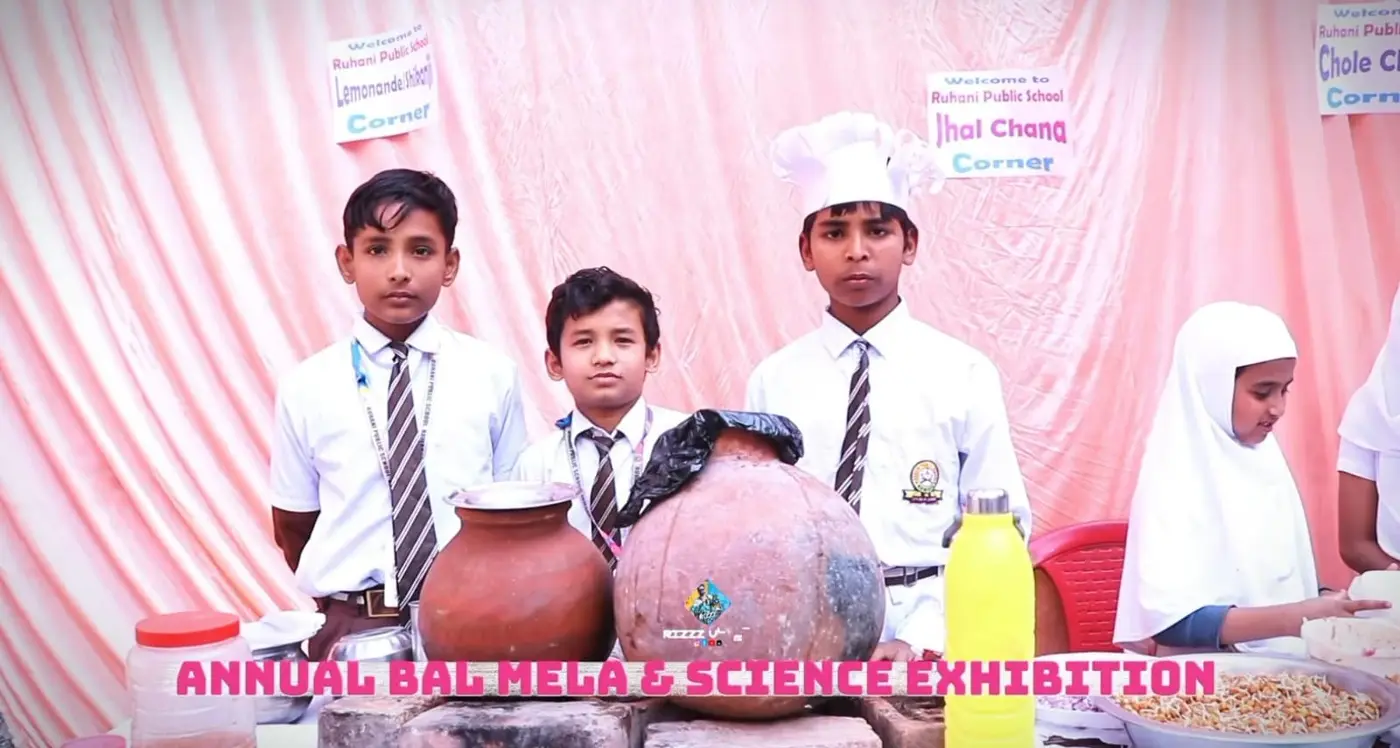 Students stand behind lemonade and snack stalls with clay pots during Annual Bal Mela.